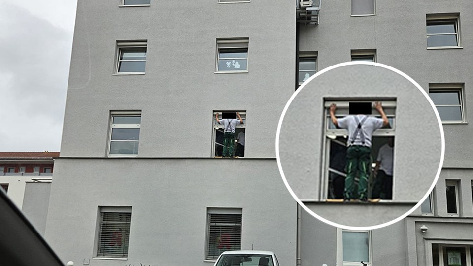 Teilansicht von außen eines mindestens fünfstöckigen Gebäudes; außen an einem geöffneten Fenster im ersten Stock steht eine Person in Arbeitskleidung und beschäftigt sich mit den Fensterrolladen. Er steht ungesichert auf einem kleinen Absatz, der schmaler ist als eine Fußlänge. In einem kleinen Kreis ist die Szene noch einmal vergrößert separat dargestellt.